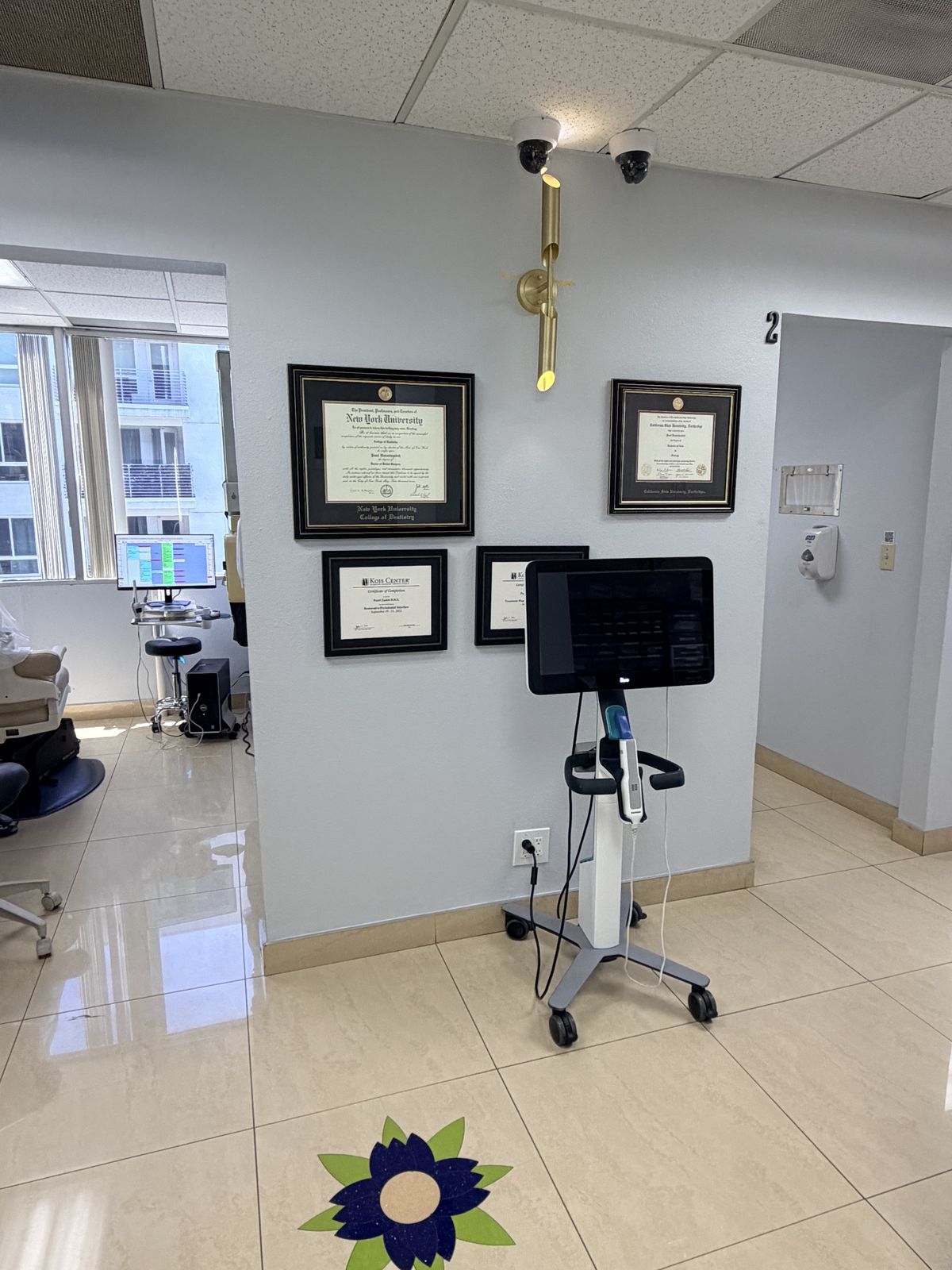 Framed diplomas and digital scanning cart in the hallway